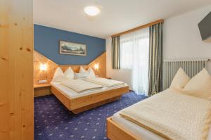 a hotel room with two beds and a window at Gästehaus Sieder by Schladming-Appartements in Schladming