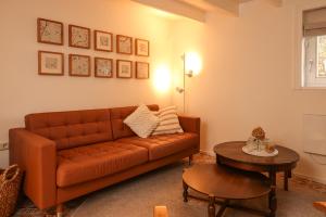 De Torteltuin في Nispen: غرفة معيشة مع أريكة بنية وطاولة