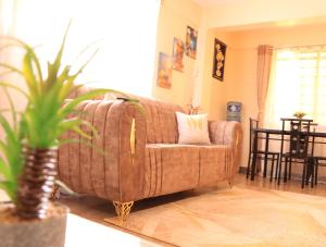 uma sala de estar com um sofá e um vaso de plantas em GP homes em Nyeri