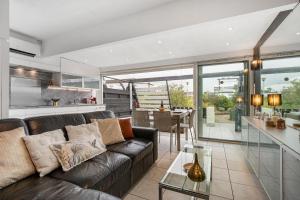 a living room with a couch and a table at Village Naturiste R4N - La Villa Beach&Club Luxe in Cap d'Agde