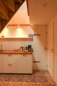 eine Küche mit einer Arbeitsplatte und einer Tür in der Unterkunft De Torteltuin in Nispen
