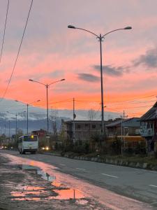 uma carrinha branca a descer uma rua ao pôr-do-sol em Aasariya Hotel And Restaurants em Srinagar