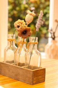 drie glazen flessen met bloemen op tafel bij De Torteltuin in Nispen
