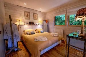 ein Schlafzimmer mit einem Bett in einem Zimmer mit Holzböden in der Unterkunft Détente au Bord de l'Eau - Le Chalet du Carla avec Spa et Ponton Privé in Castelnau-de-Lévis