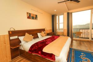 una camera con un grande letto e un balcone di Himalayan Suite a Dharamshala