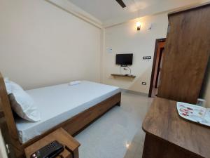 a bedroom with a bed and a television in it at Hotel Hari Gayatri Regent in Guwahati