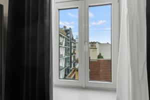 an open window with a view of a city at Stylish Apartment, 4 min to U3 Zipperer Straße in Vienna