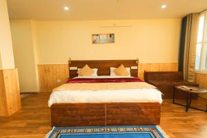 um quarto com uma cama grande e um sofá em Himalayan Suite em Dharamshala