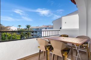a balcony with a wooden table and chairs at Albatros 2 in Denia