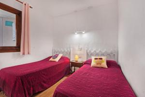 two beds in a room with purple sheets on them at Albatros 2 in Denia +13 photos