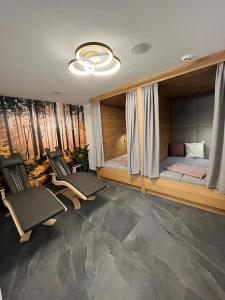 Zimmer mit 2 Stühlen, einem Bett und Fenstern in der Unterkunft Pension Edelweiß in St. Johann im Pongau