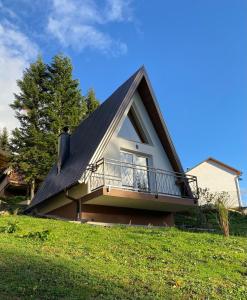 BusovačaにあるAlpi Cabin Pridolciのバルコニー付きのガムブル屋根の家