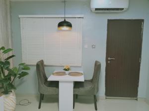 a table and chairs in a room with a door at 1 Bedroom Entire APT - Kitchen - Wi-Fi in Ikeja