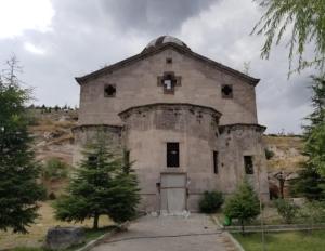 een oud stenen gebouw met een boom ervoor bij Beyaz Konak Pansiyon 2 in Gülşehir