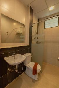 a bathroom with a toilet and a sink and a shower at Hills Aranda Nova Hotel in Cameron Highlands