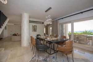 una sala da pranzo con tavolo e sedie di Bodrumda Eşsiz Deniz Manzaralı Lüks Villa Boss 1 a Milas