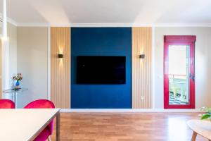 a living room with a blue wall with a flat screen tv at Ubicación Perfecta Apartamento Luxury Beach in Málaga