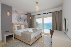 una camera da letto con un letto grande e una grande finestra di Bodrumda Eşsiz Deniz Manzaralı Lüks Villa Boss 1 a Milas Altre 57 foto