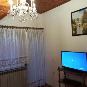 een woonkamer met een kroonluchter en een televisie bij Happy 80's in Belgrado