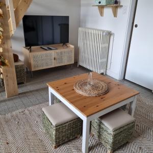 een woonkamer met een tafel en een televisie bij Studio Gypsy in Isigny-le-Buat