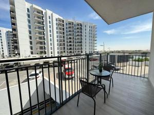 balcón con mesa y sillas y algunos edificios en Comfy is just a holiday home! 105WB2, en Abu Dabi