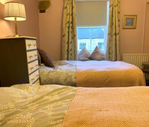 a bedroom with two beds and a window at Spacious Georgian Apartment, Central Barnard Castle. in Barnard Castle