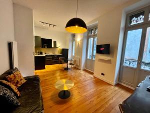 una sala de estar con un sofá y una mesa en Appartement Haut de Gamme, Balnéo/ Balcon/ Garonne, en Toulouse