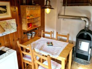 mesa de madera con sillas y estufa de leña en Rustic alpine hut in Vordernberg with sauna, en Vordernberg