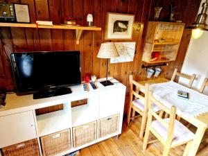 a living room with a tv and a table with a chair at Rustic alpine hut in Vordernberg with sauna in Vordernberg
