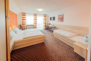ein Hotelzimmer mit 2 Betten und einem Schreibtisch in der Unterkunft Hotel Sonnental in Neusorg