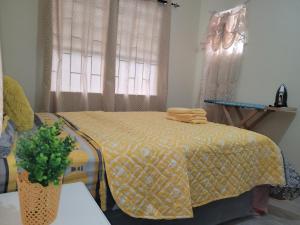 a bedroom with a bed with a yellow comforter at Kensington Oval- 2 bed 1 Bath in Bridgetown