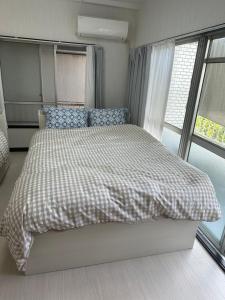 1 dormitorio con 1 cama con manta a cuadros en 駅1分空港Airport近い, en Tokio