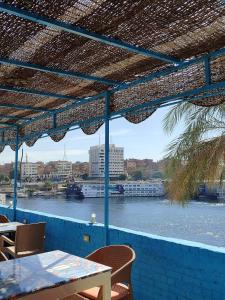 a view of a river from a patio with a table and chairs at Jamaica Guest House in Aswan