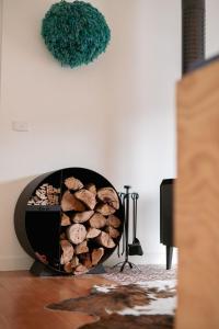 a fire pit filled with logs in a living room at The Wooden House in Bright