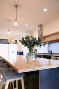 a kitchen with a large wooden table with a vase of flowers at The Wooden House in Bright +61 photos