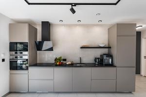 a kitchen with white cabinets and a black counter top at Dom nad Zalewem in Czorsztyn