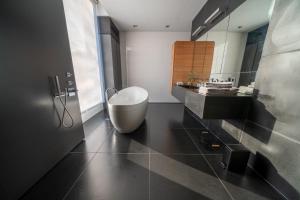 a bathroom with a white tub and a sink at Bed & Wellness Boxtel, luxe kamer met airco en eigen badkamer, ligbad in Boxtel