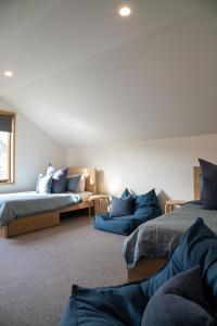 um quarto com duas camas com almofadas azuis em The Wooden House em Bright