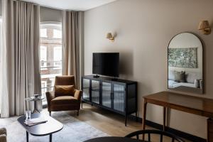 a living room with a television and a chair at Native Kings Wardrobe in London