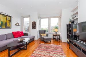 a living room with a couch and a tv at Beautiful 2BR Flat, Peaceful Dulwich, South London in London