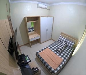 a small bedroom with a bed and a mirror at Omah Nogotirto Homestay Jogja in Ngingas