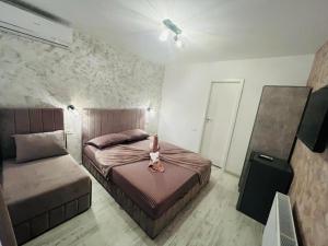 a bedroom with two beds and a girl sitting on the bed at Ama Boutique in Constanţa