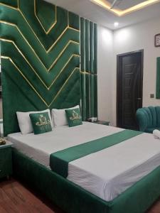 een slaapkamer met een groot bed met groene en witte lakens bij Hotel Royal Galaxy in Lahore