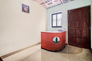 een kamer met een houten deur en een rode tafel bij OYO Hotel 49339 On The Rocks in Arambol