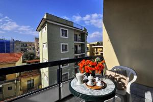 Un balcón con una mesa con flores. en Casa Margherita, en Sorrento