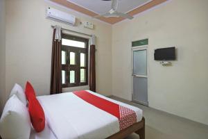 a bedroom with a bed and a tv on the wall at OYO 62761 Hotel Daksh in Mahendragarh