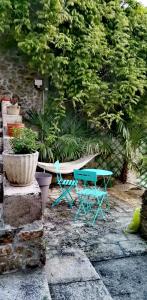 a bench and a table and chairs in a garden at La Dolce Vita Camille in Vals-les-Bains