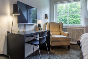 une chambre d'hôtel avec un bureau et une chaise dans l'établissement Thon Partner Hotel Sorø, à Sorø