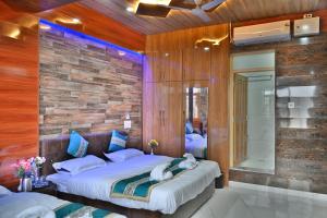 1 dormitorio con 2 camas y pared de ladrillo en Aasariya Hotel And Restaurants en Srinagar