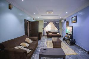 a living room with two couches and a tv at Home away from Home. in Galadima